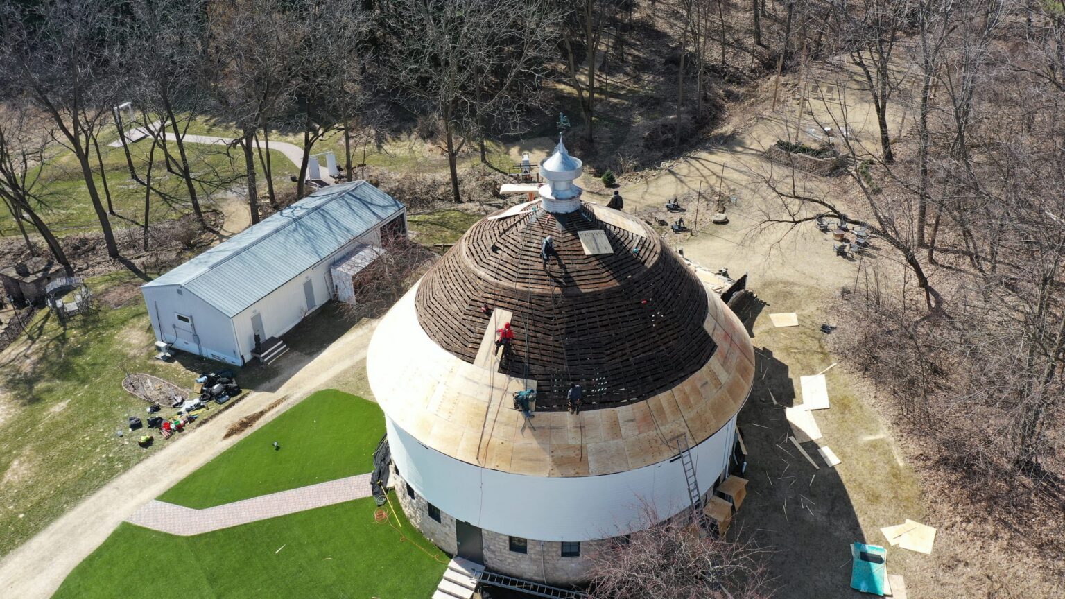 Round barn roof restoration in progress, aerial view