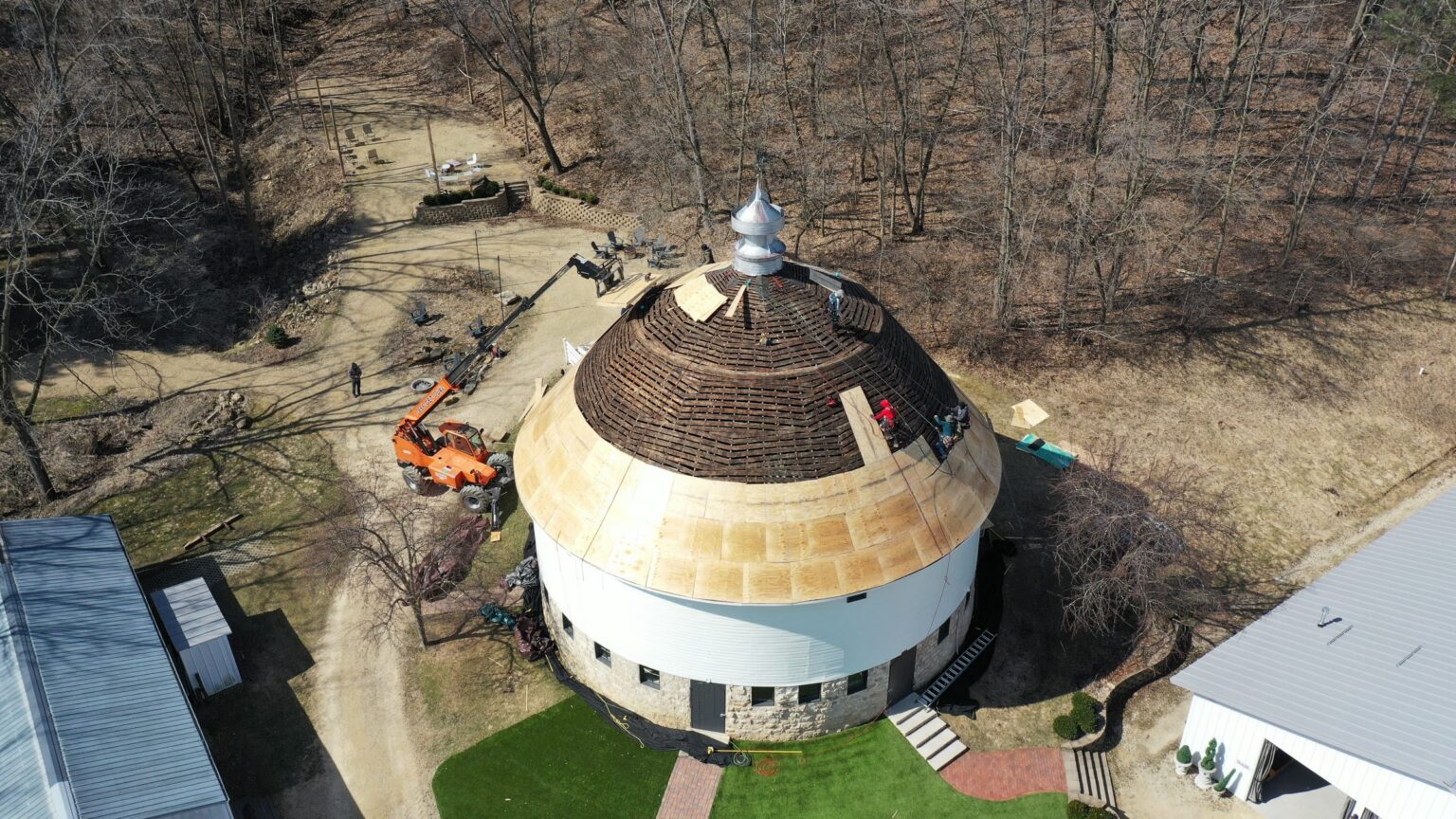 Round barn roof restoration in progress, aerial view