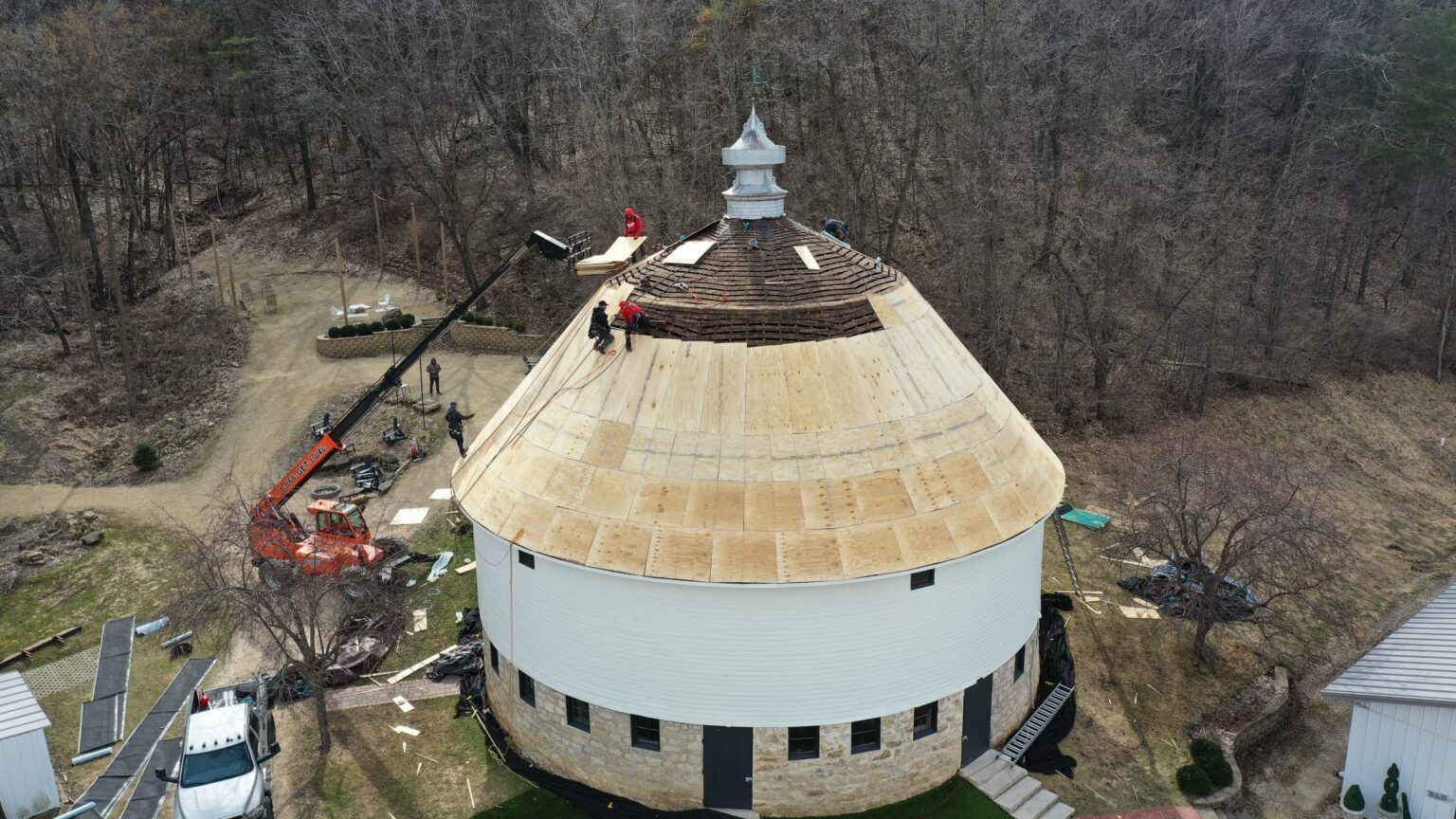 Round barn roof restoration in progress, aerial view