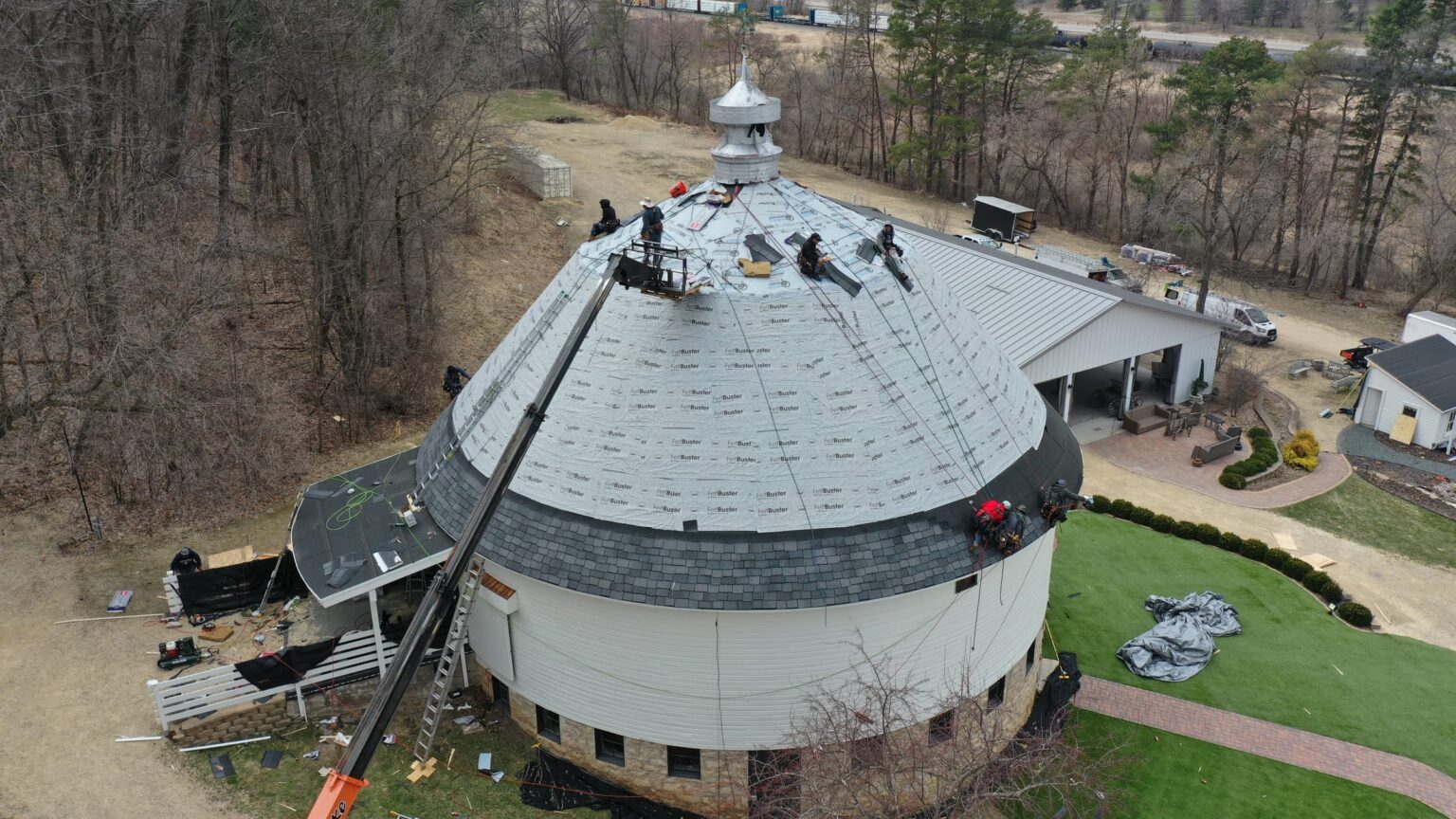 Jacobs Construction crew shingling the round barn's dome roof