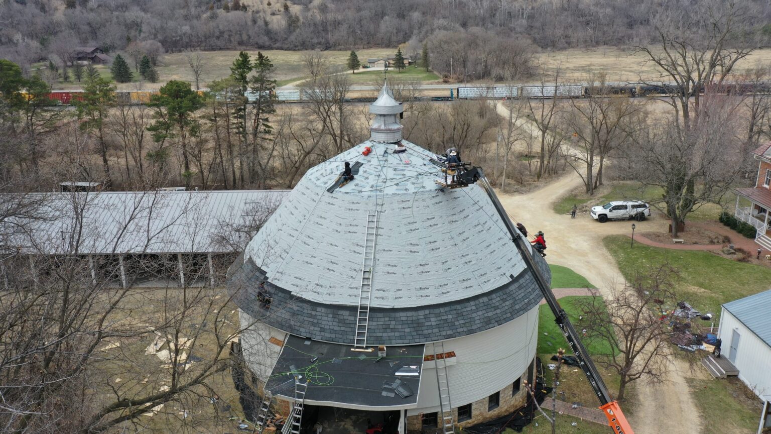 Crew installing underlayment on the round barn dome