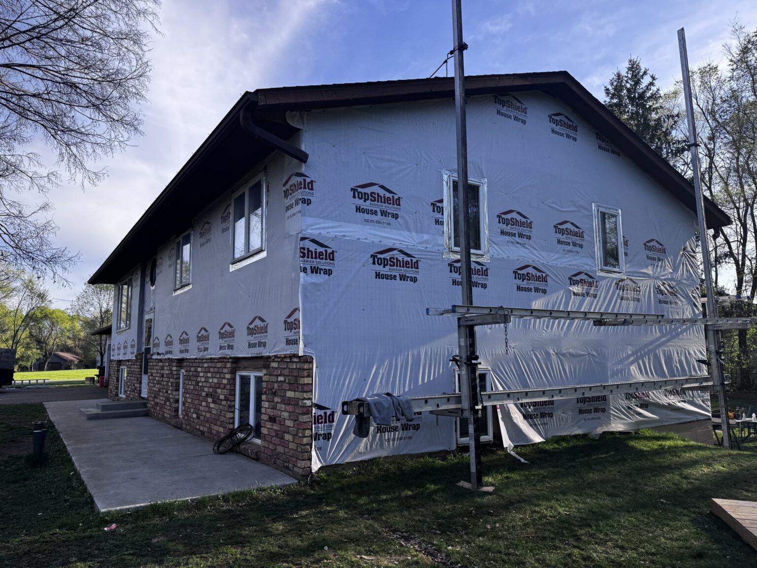 Taped house wrap seams and window flashing during siding prep